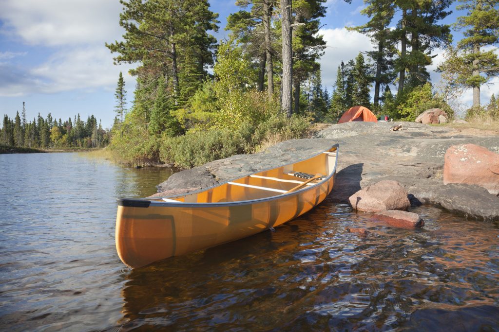 45431539 - a campsite with a yellow canoe on a rocky shore of a boundary waters lake in minnesota